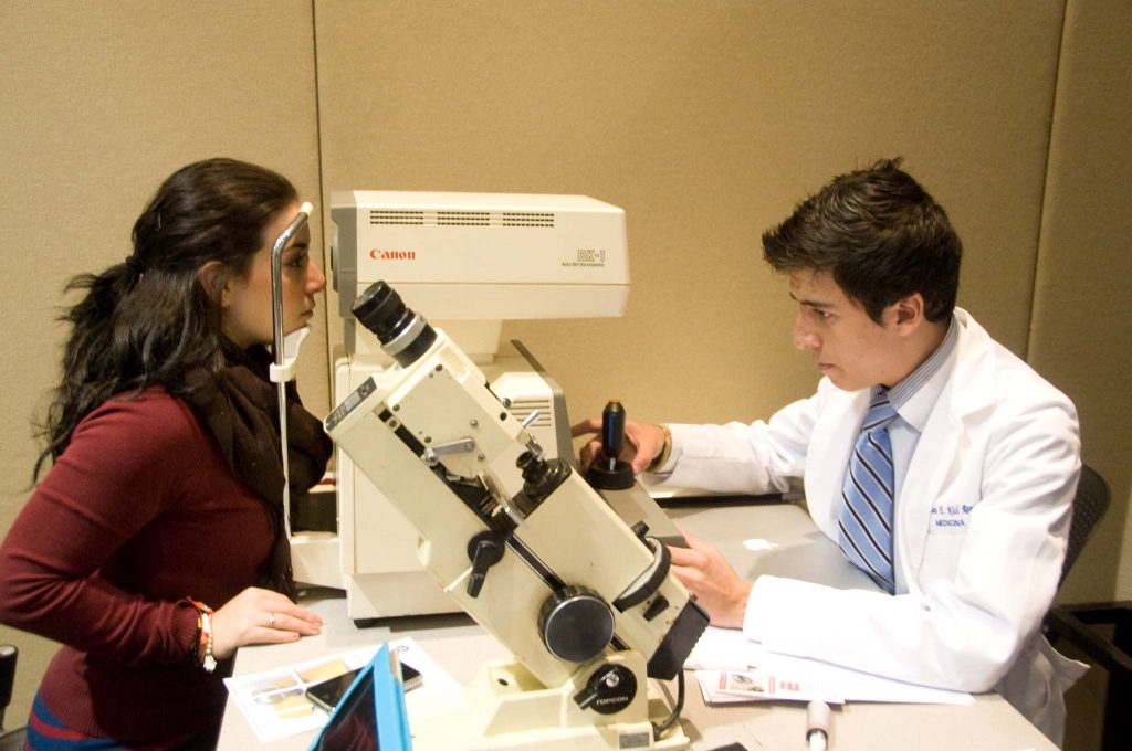 Medical student giving an eye exam